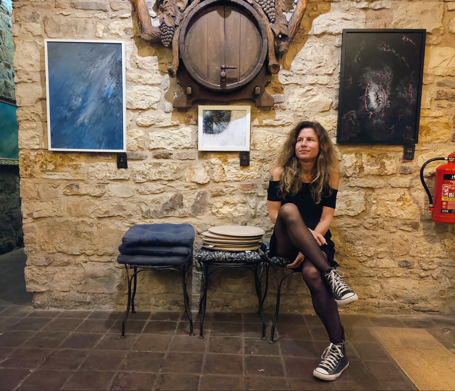 Kateřina Murová among her paintings in a wine cellar